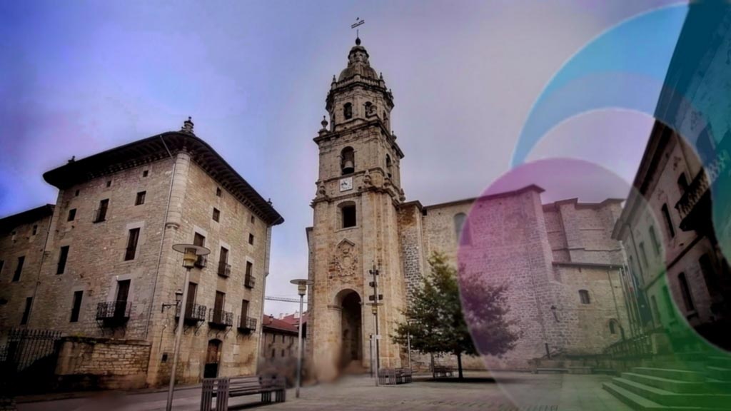 Fotografía que muestra la plaza de Ariznoa de Bergara con la torre olaso, la parroquia de san pedro y el palacio de justicia y medio logotipo de Feel Euskadi